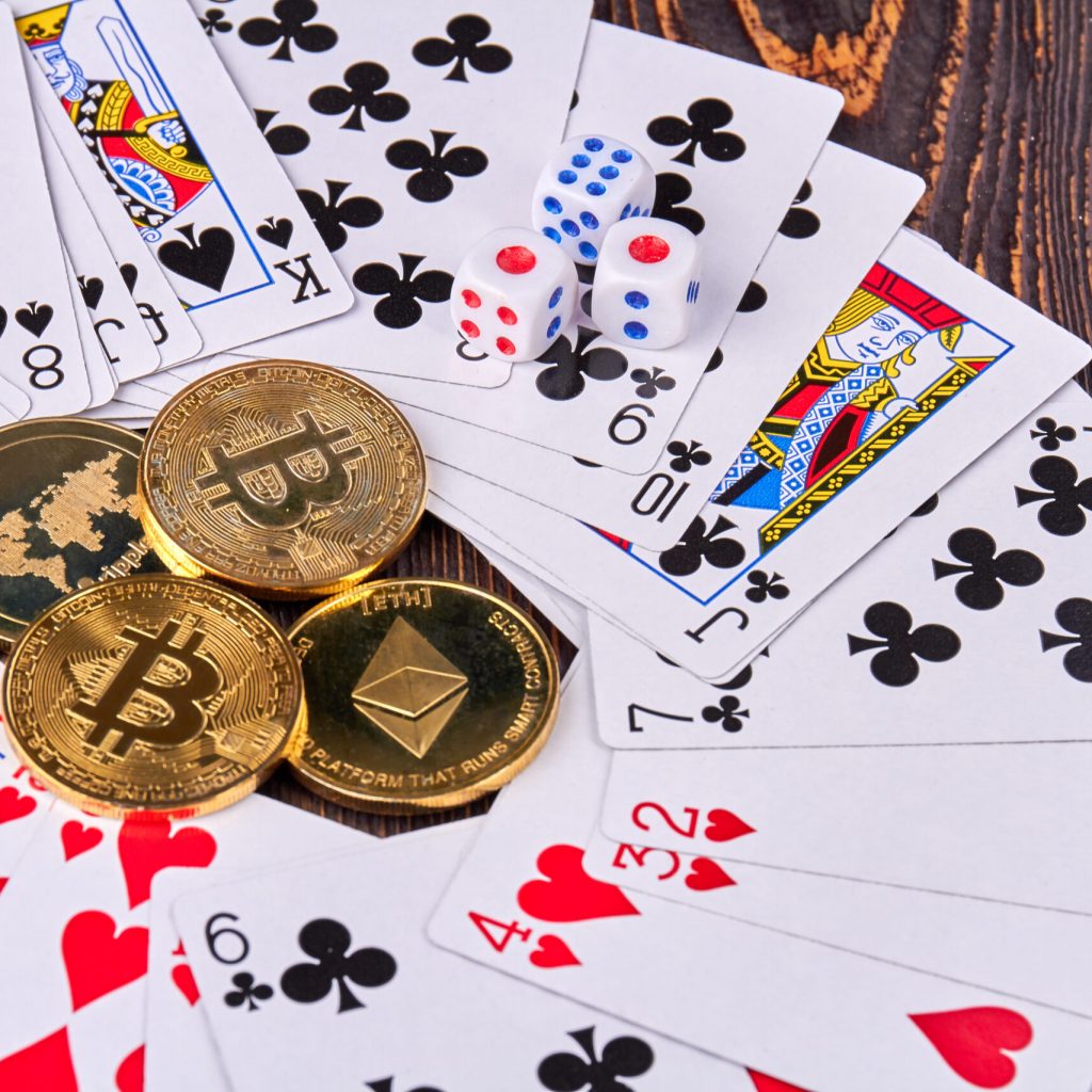 Close-up bitcoins with cards and dices on wooden desk. Cryptocurrencie gambling concept.