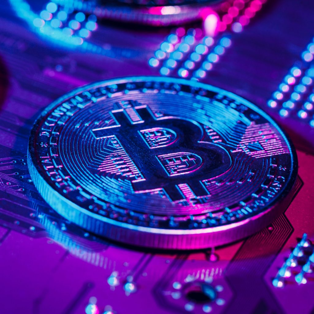 golden bitcoin and computer chip in background. Close up.